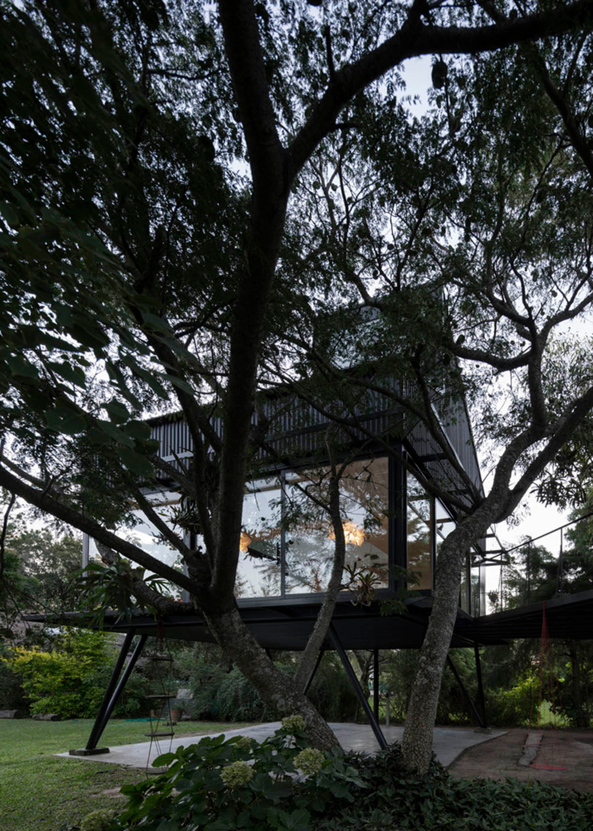 This black metal tree house by Paschetta Cavallero Arquitectos disappears between the treetops