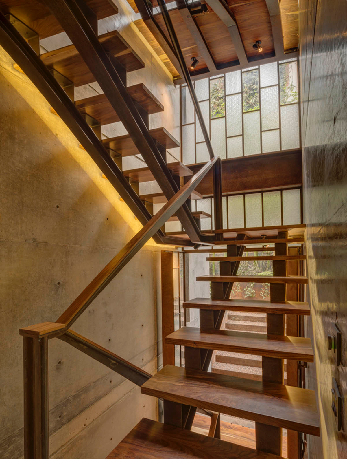 Triangular and faceted green terraces provide generous open spaces for this residence by Vertebral