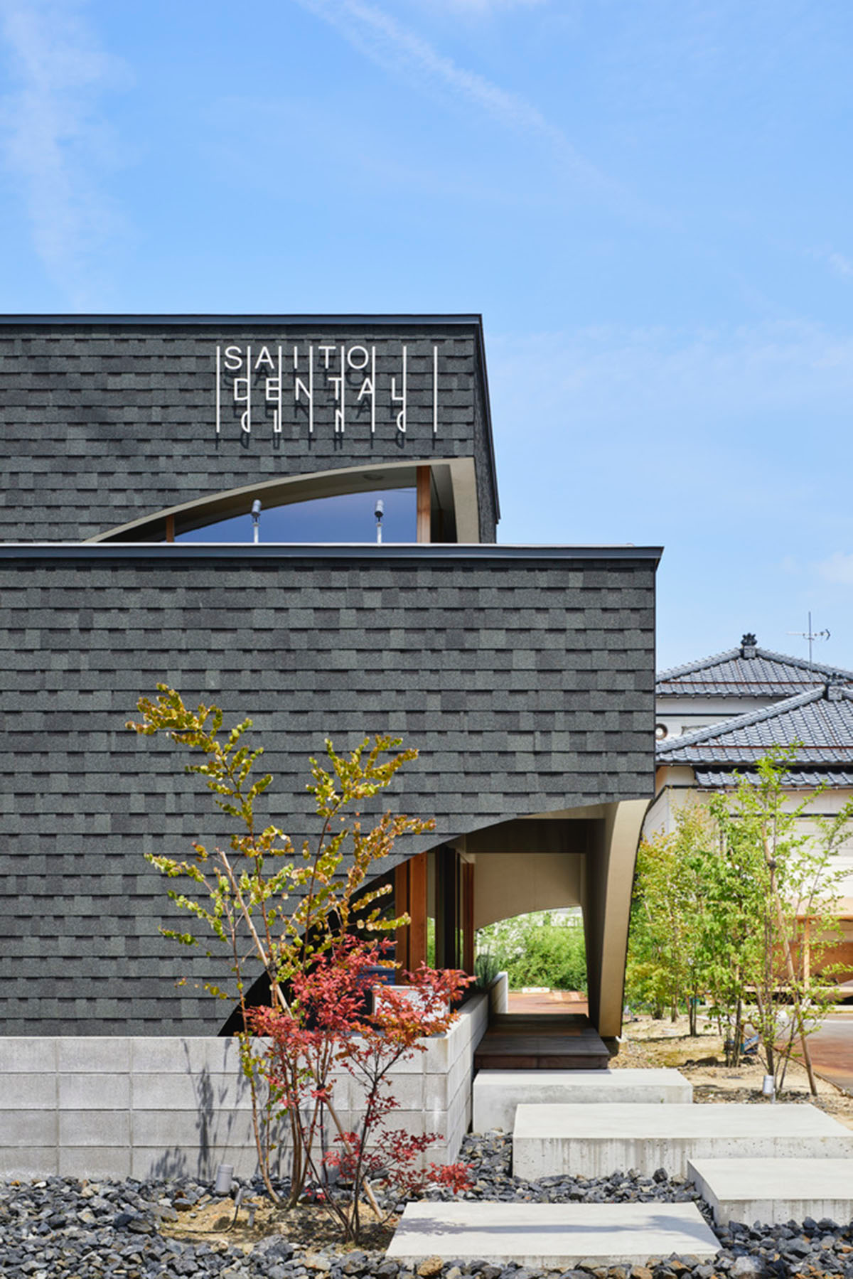 A dental clinic and daycare center are hidden under arches in Japan by Takeru Shoji Architects