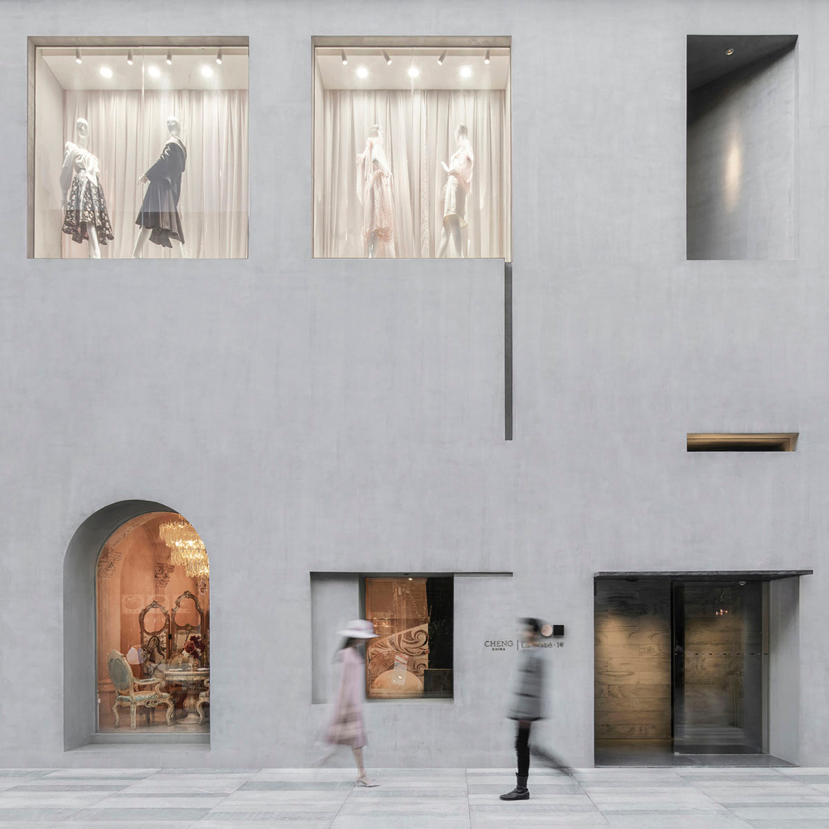 Pink elements and dark colors create sharp contrast in the interiors of restaurant and showroom