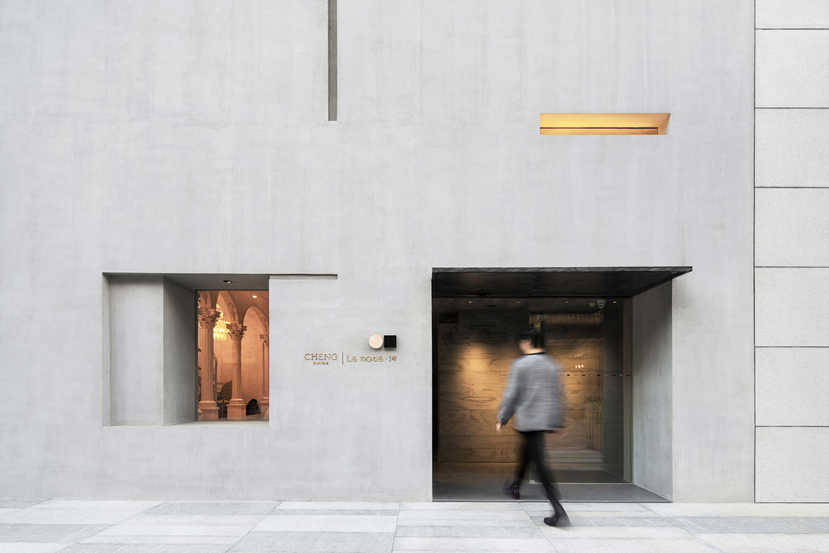 Pink elements and dark colors create sharp contrast in the interiors of restaurant and showroom