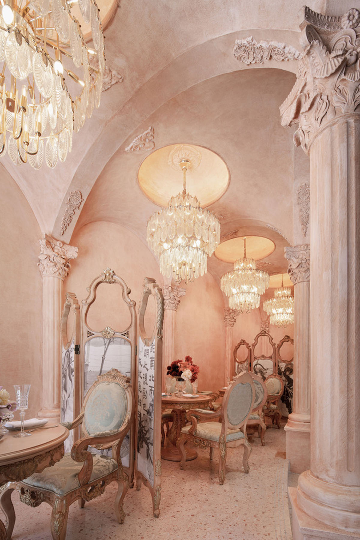 Pink elements and dark colors create sharp contrast in the interiors of restaurant and showroom