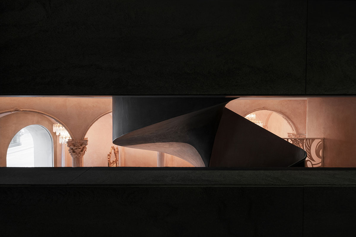 Pink elements and dark colors create sharp contrast in the interiors of restaurant and showroom