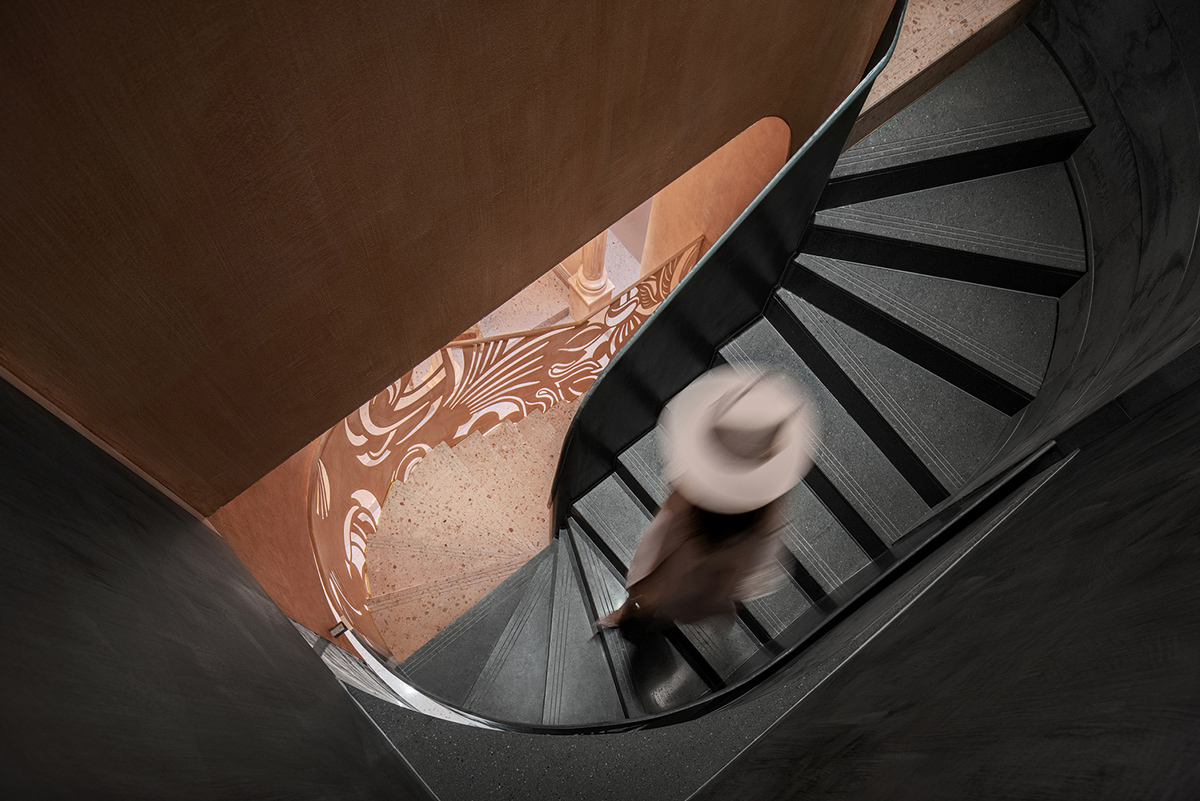 Pink elements and dark colors create sharp contrast in the interiors of restaurant and showroom