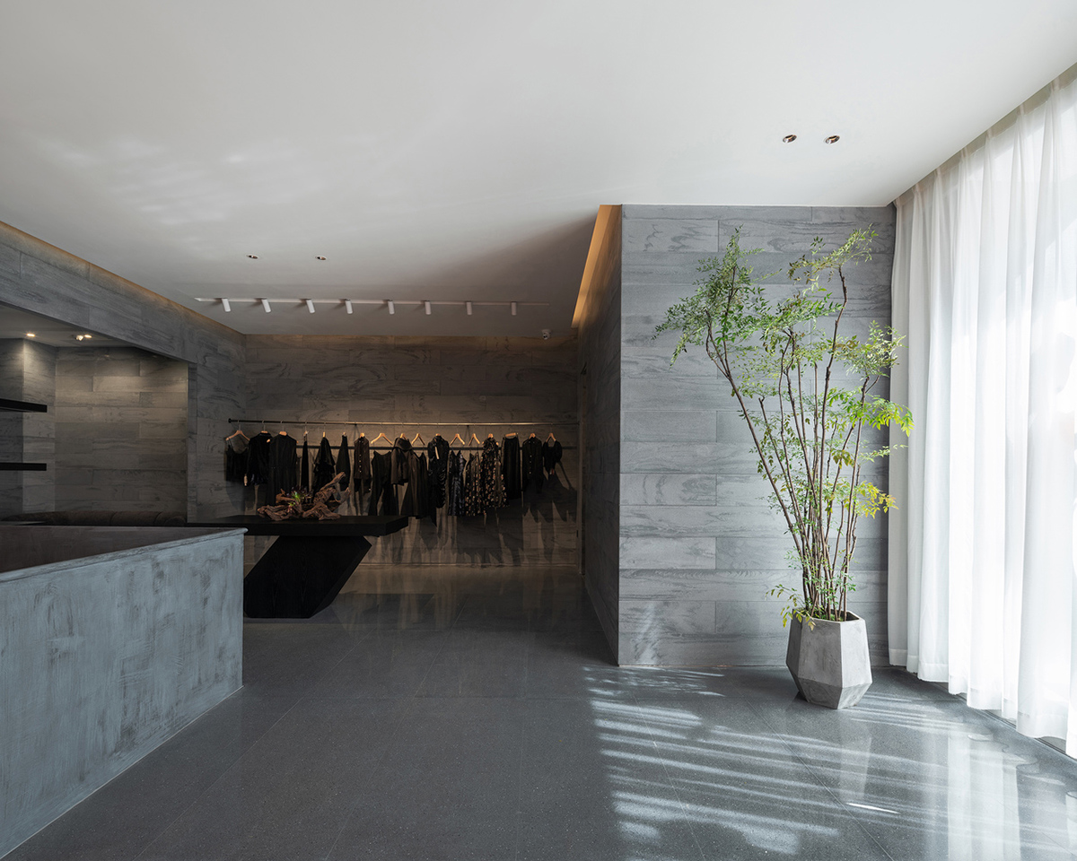 Pink elements and dark colors create sharp contrast in the interiors of restaurant and showroom