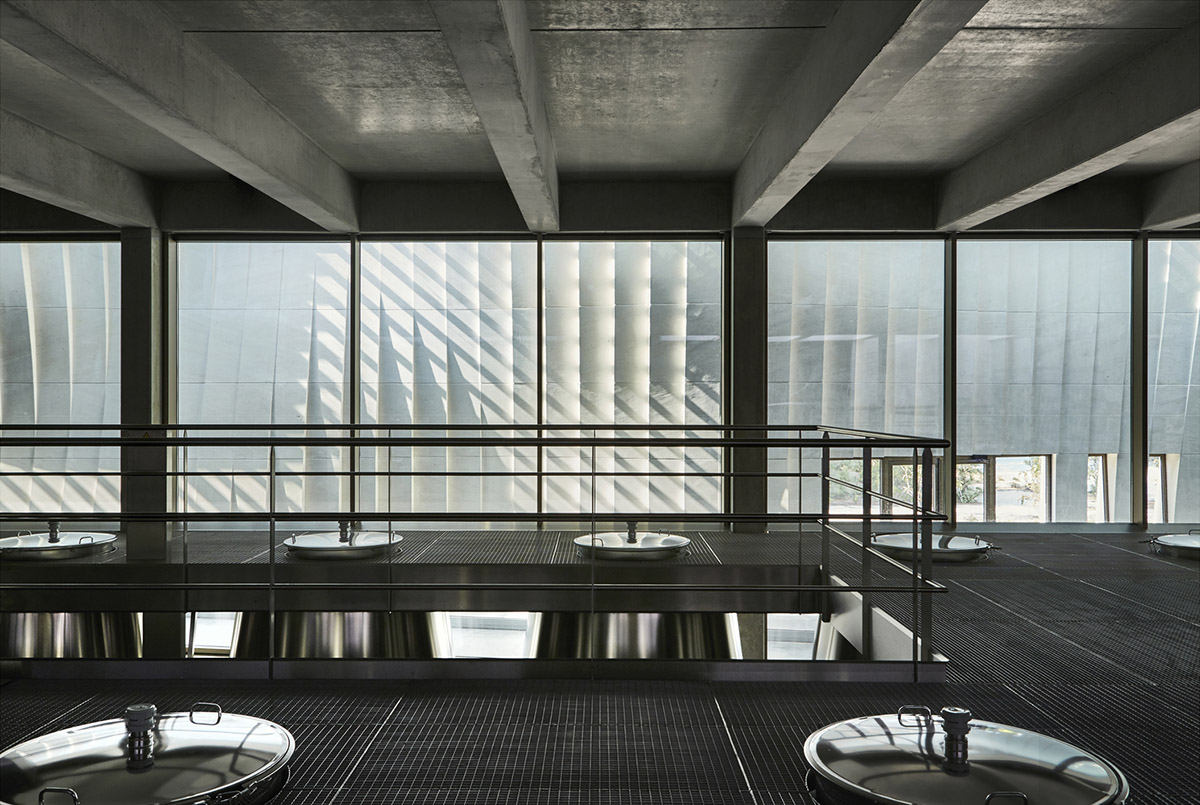 Curving stone solid walls form this winery and guide visitors for winemaking process in France