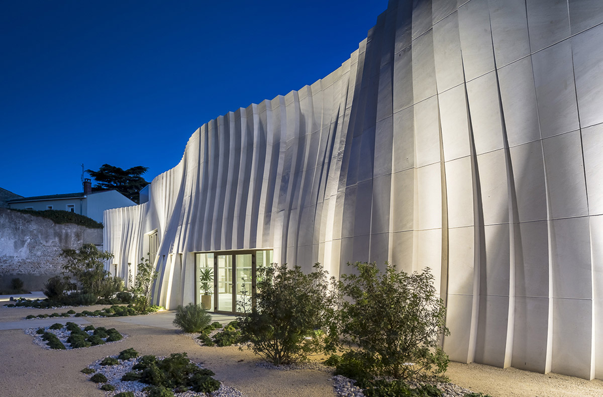 Curving stone solid walls form this winery and guide visitors for winemaking process in France