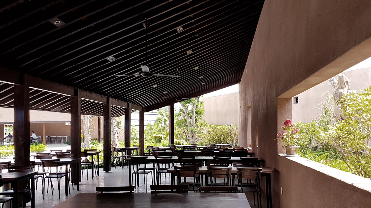 TAA DESIGN built public space with pitched roofs and rough concrete walls painted with pink tones