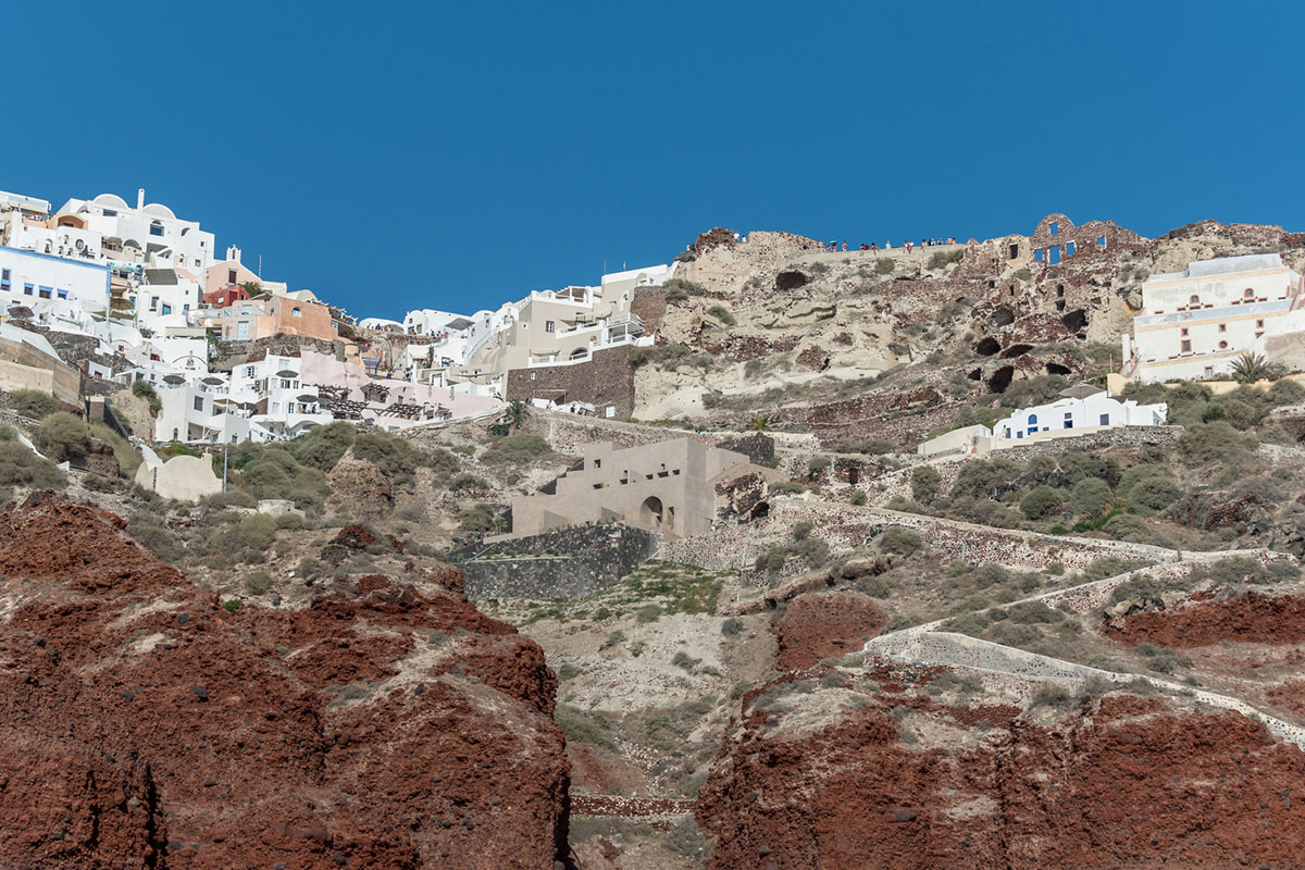 Kapsimalis Architects built castle-like hotel almost disappearing it on a steep hillside of Oia