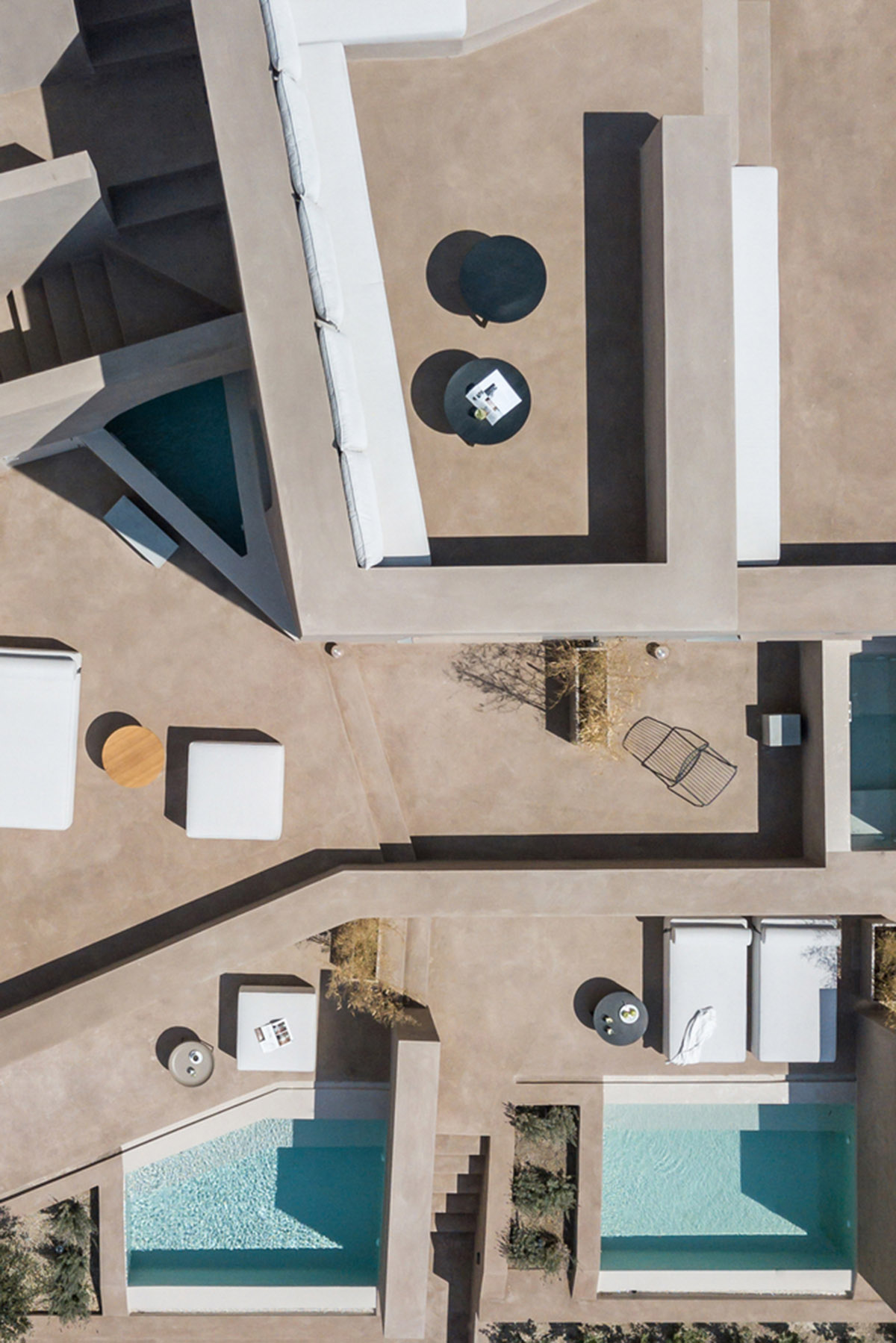 Kapsimalis Architects built castle-like hotel almost disappearing it on a steep hillside of Oia