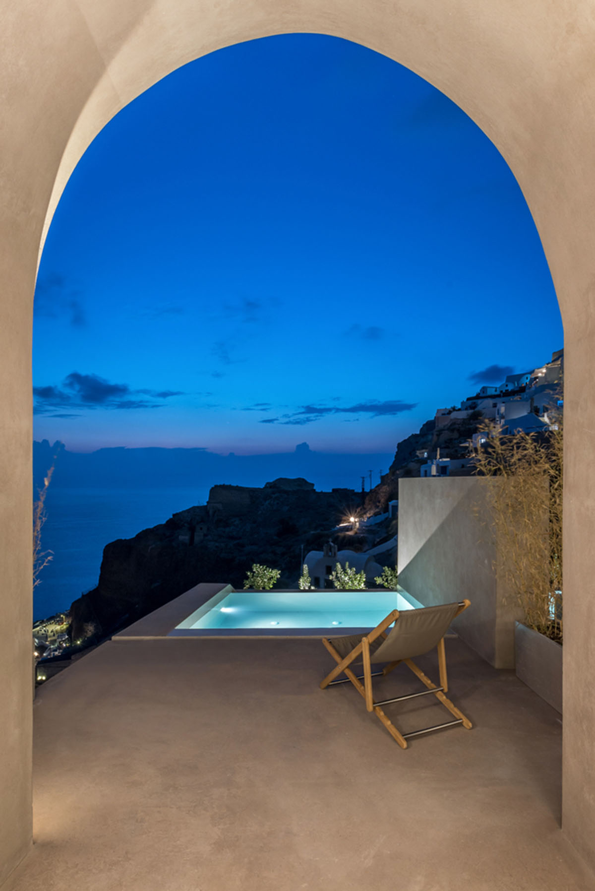 Kapsimalis Architects built castle-like hotel almost disappearing it on a steep hillside of Oia
