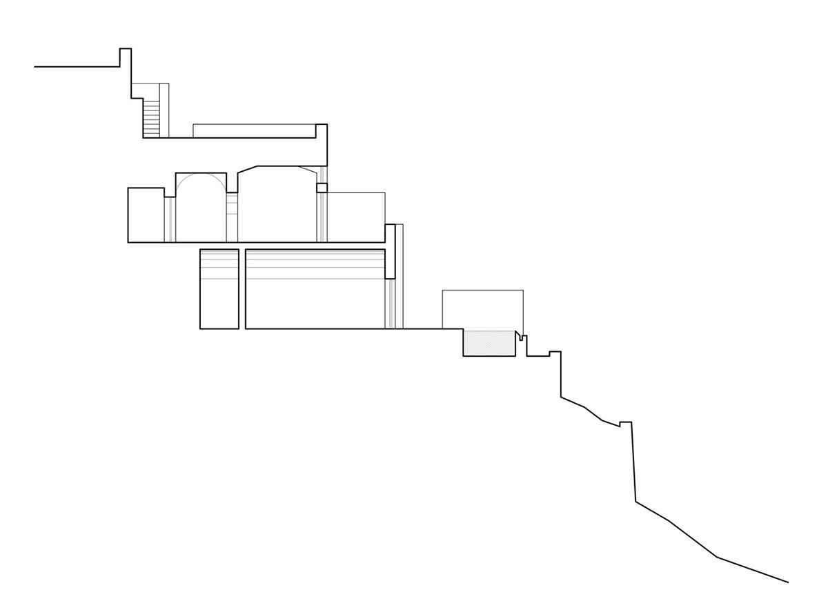 Kapsimalis Architects built castle-like hotel almost disappearing it on a steep hillside of Oia