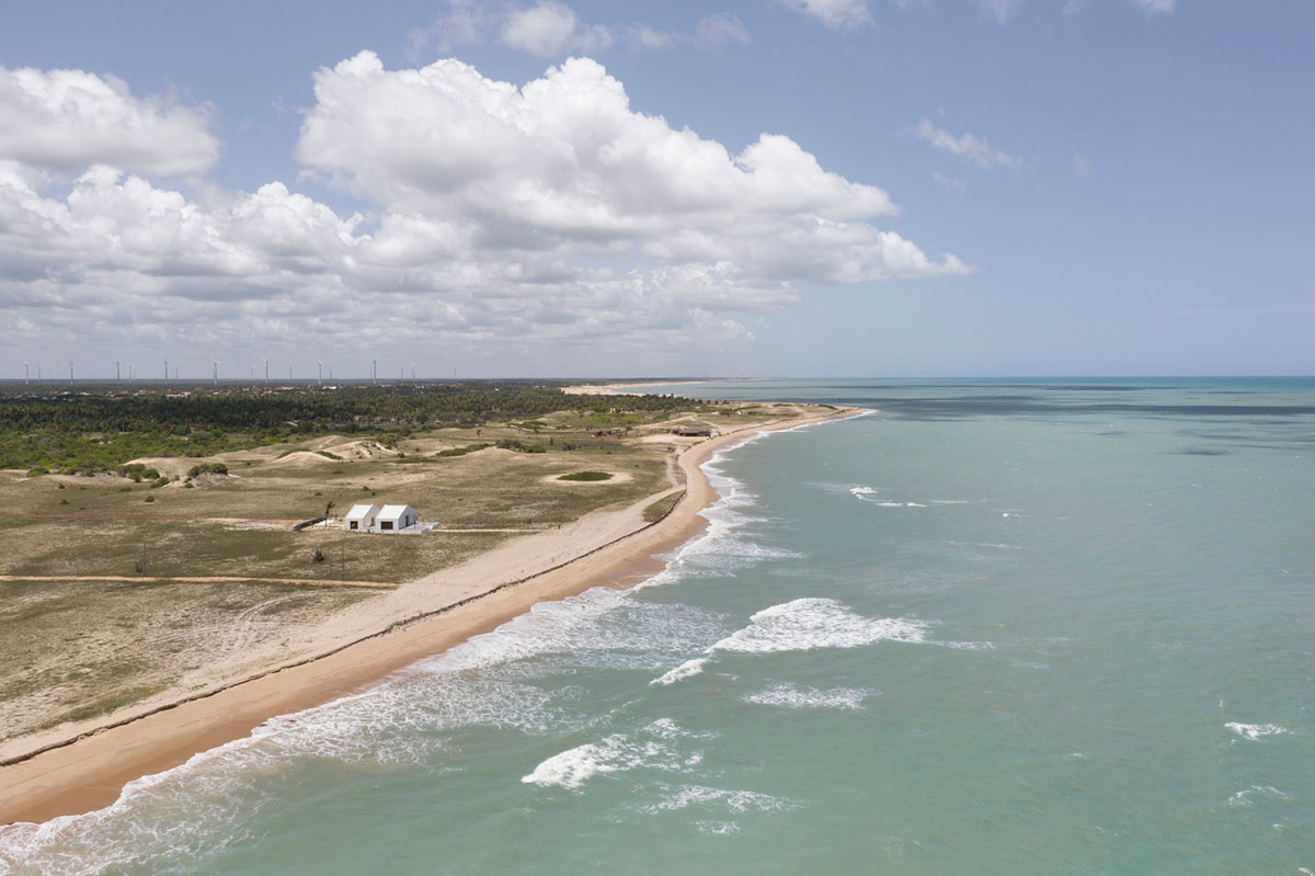 Two identical all-white volumes form this house by Atelier Branco Arquitetura on a flat landscape