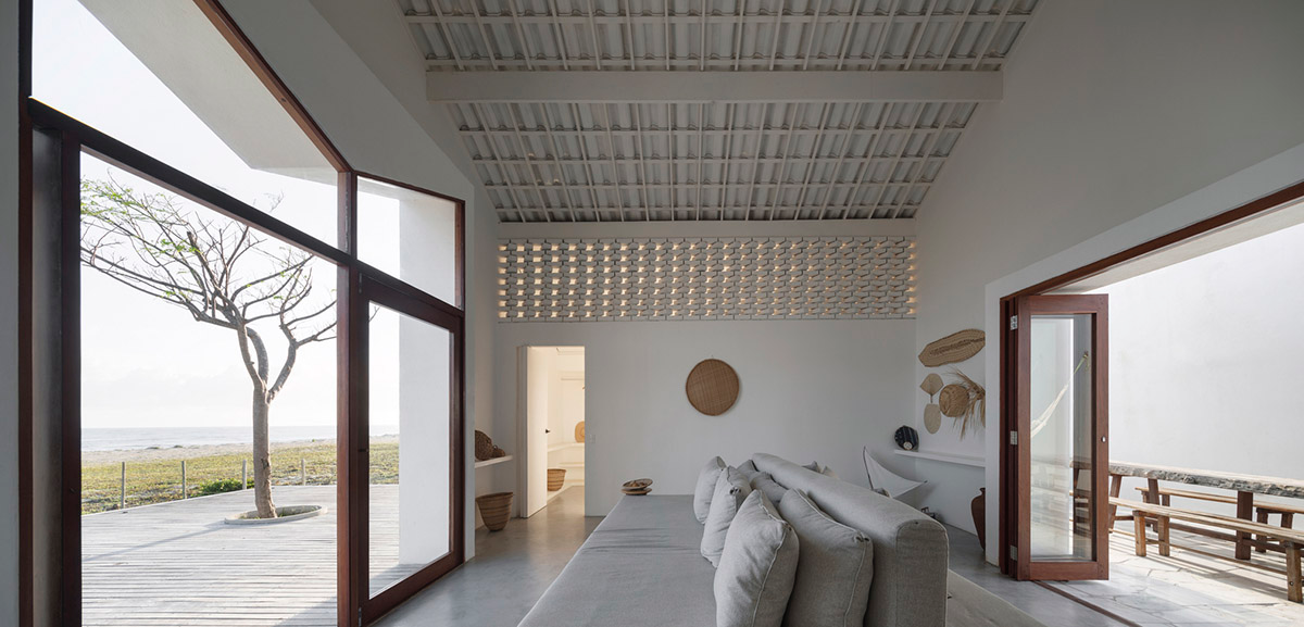 Two identical all-white volumes form this house by Atelier Branco Arquitetura on a flat landscape