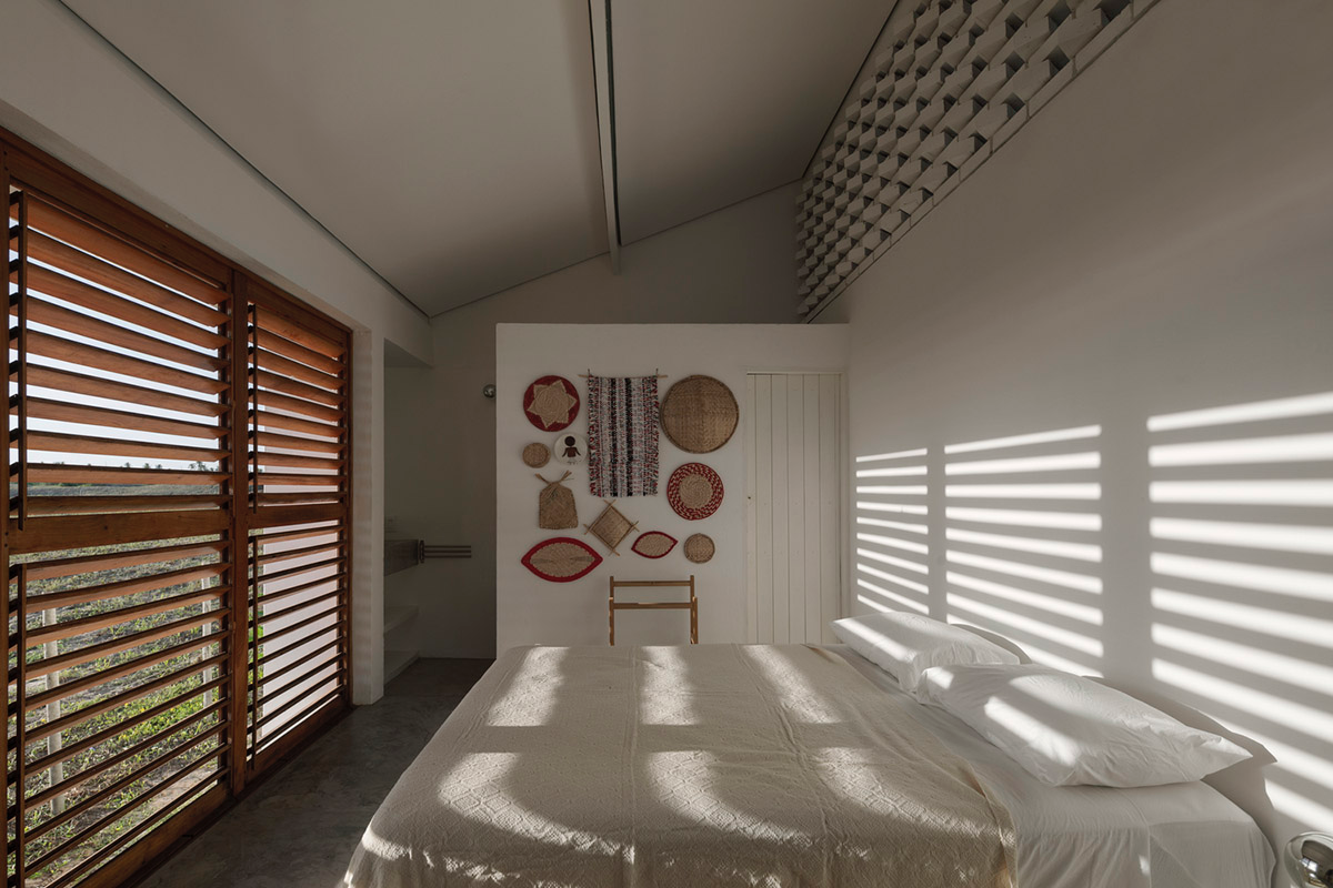 Two identical all-white volumes form this house by Atelier Branco Arquitetura on a flat landscape