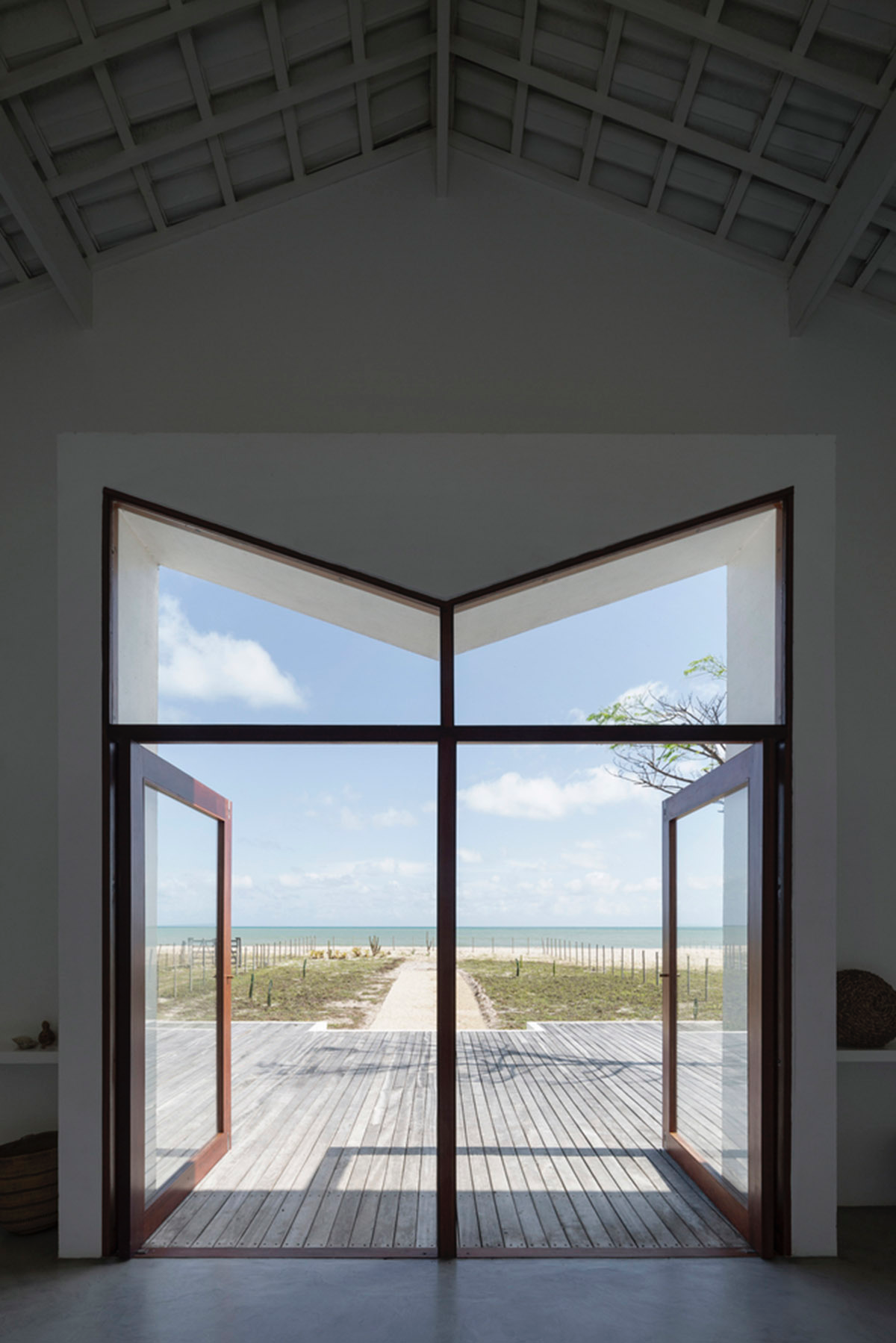 Two identical all-white volumes form this house by Atelier Branco Arquitetura on a flat landscape