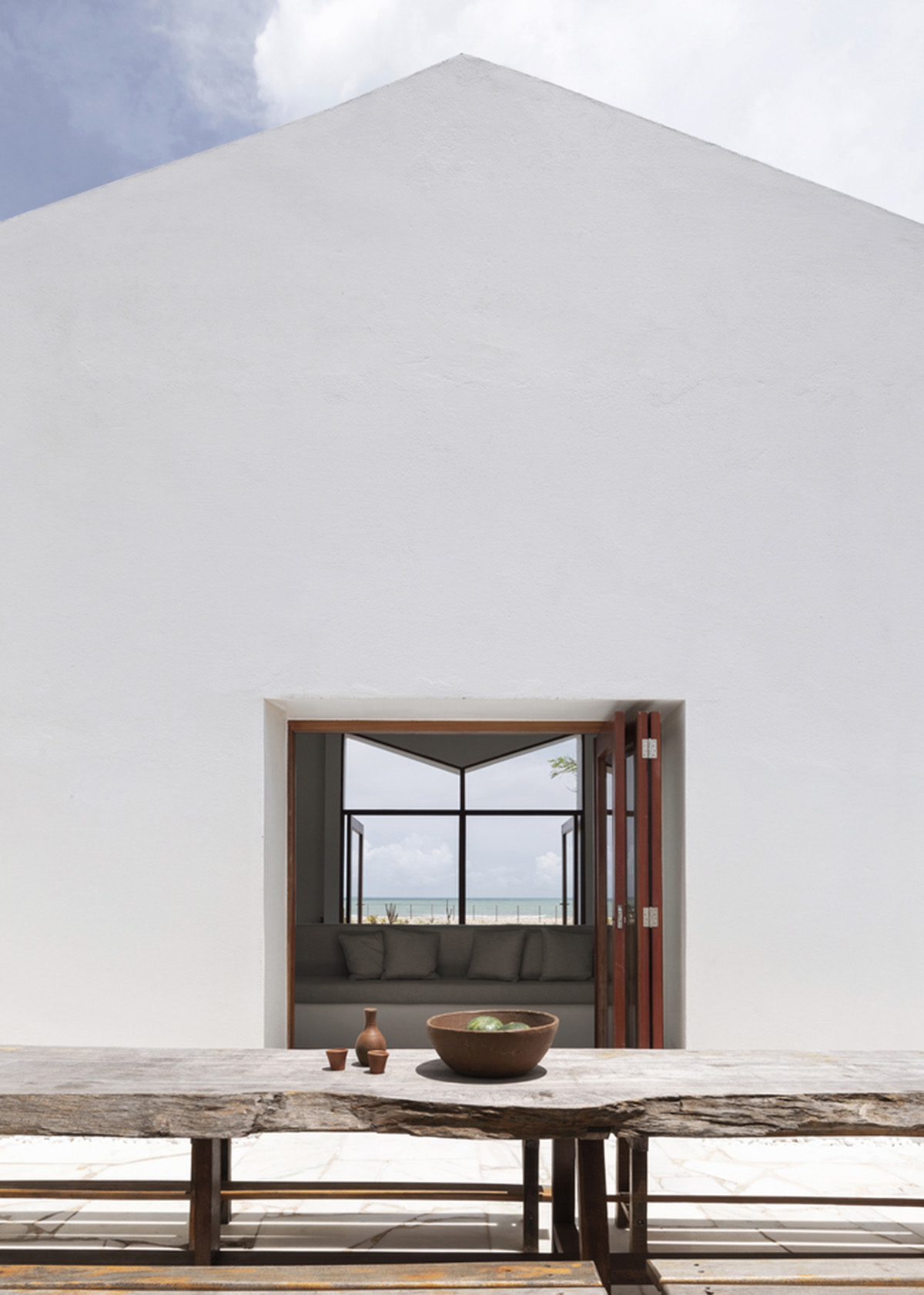Two identical all-white volumes form this house by Atelier Branco Arquitetura on a flat landscape
