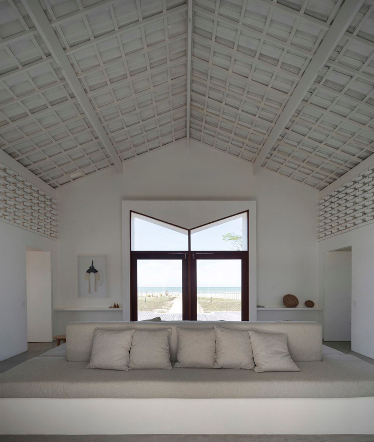 Two identical all-white volumes form this house by Atelier Branco Arquitetura on a flat landscape