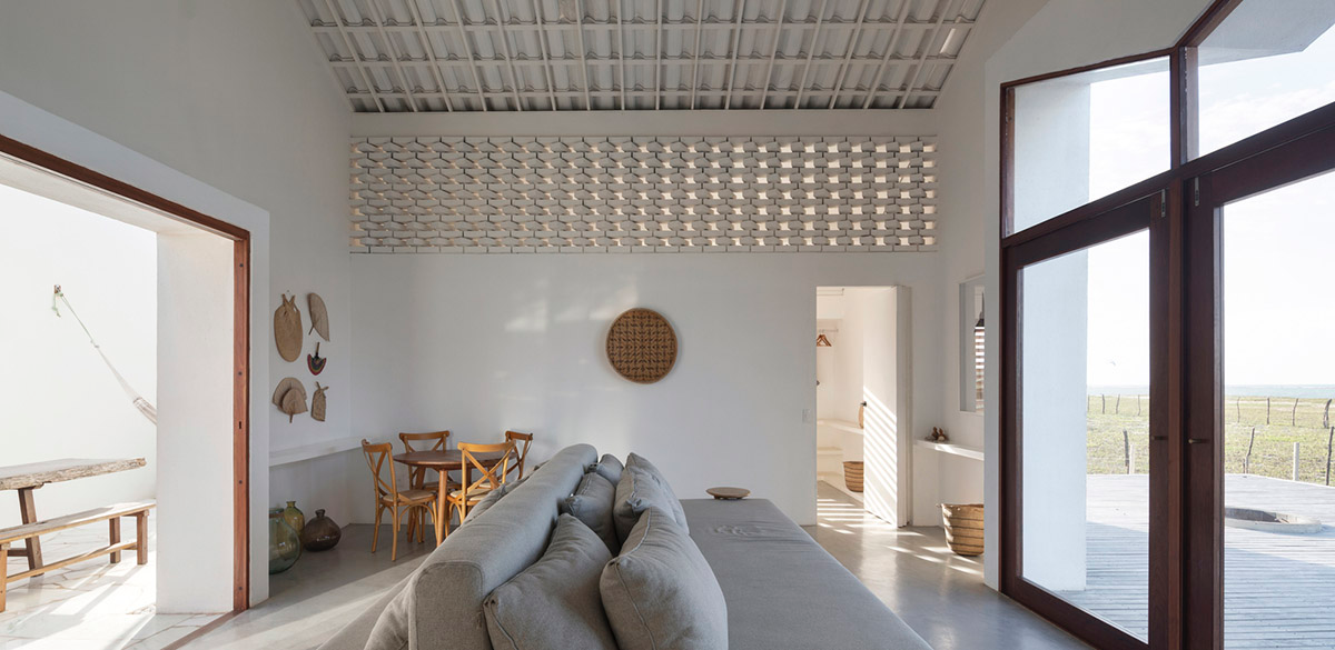 Two identical all-white volumes form this house by Atelier Branco Arquitetura on a flat landscape