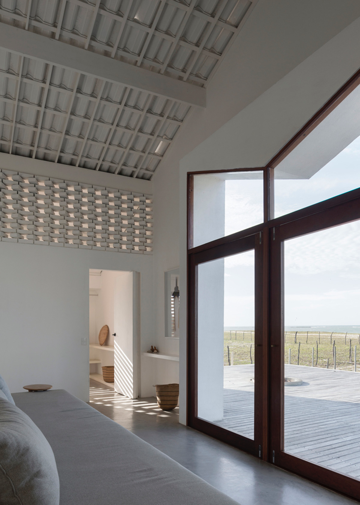 Two identical all-white volumes form this house by Atelier Branco Arquitetura on a flat landscape