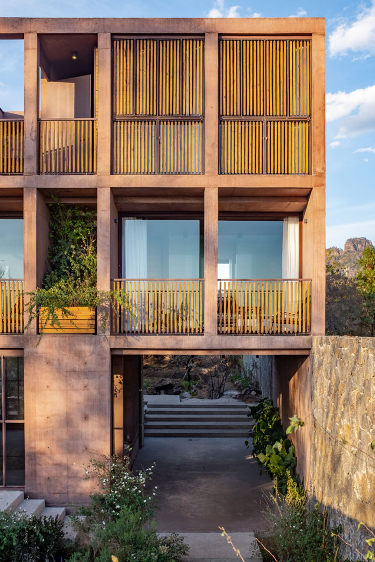 This gridded hotel made from pigmented concrete and volcanic stone sits on rugged terrain in Mexico