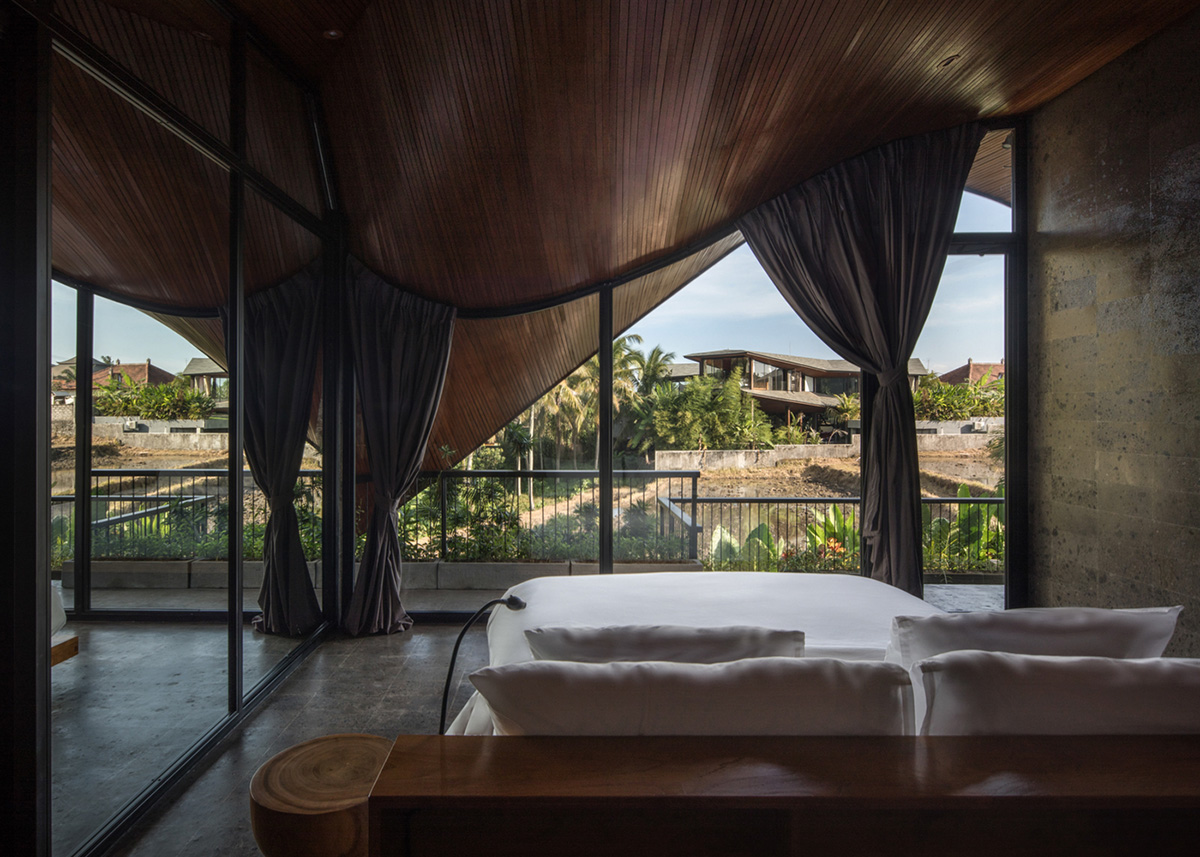 Twisted roof becomes walls and facade in Alpha House designed by Alexis Dornier in Bali
