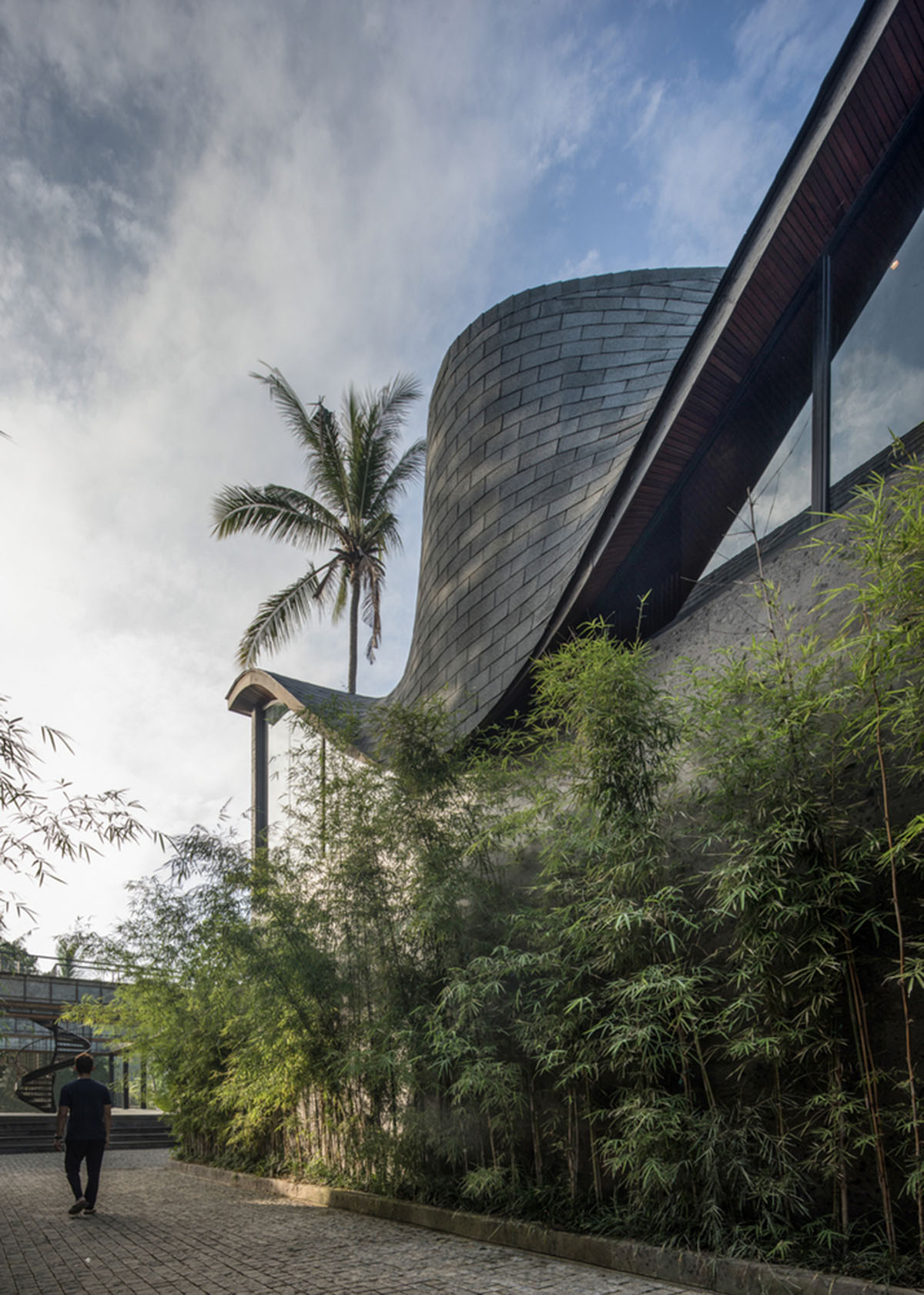 Twisted roof becomes walls and facade in Alpha House designed by Alexis Dornier in Bali