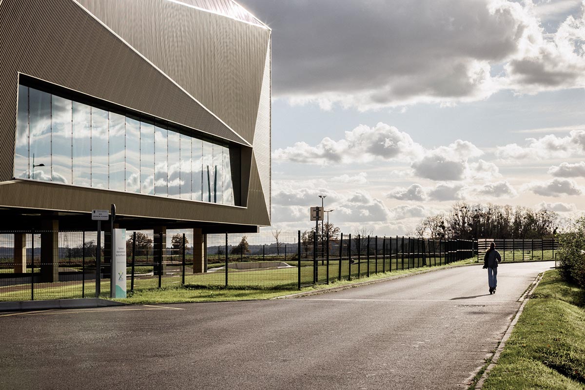 The gold-colored, folded facade gives a striking and symbolic presence to a new sports complex 