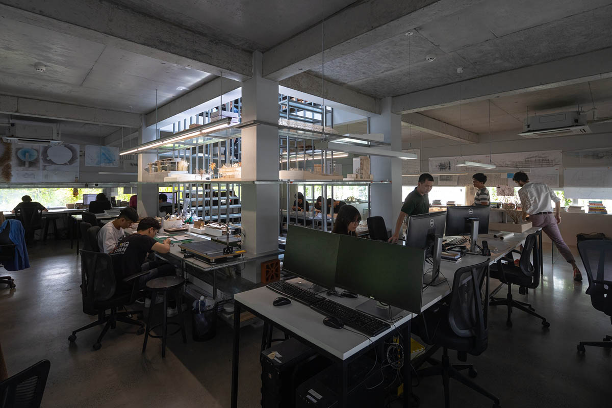 MIA Design Studio created vertical open library inside its office filled with greenery in Vietnam