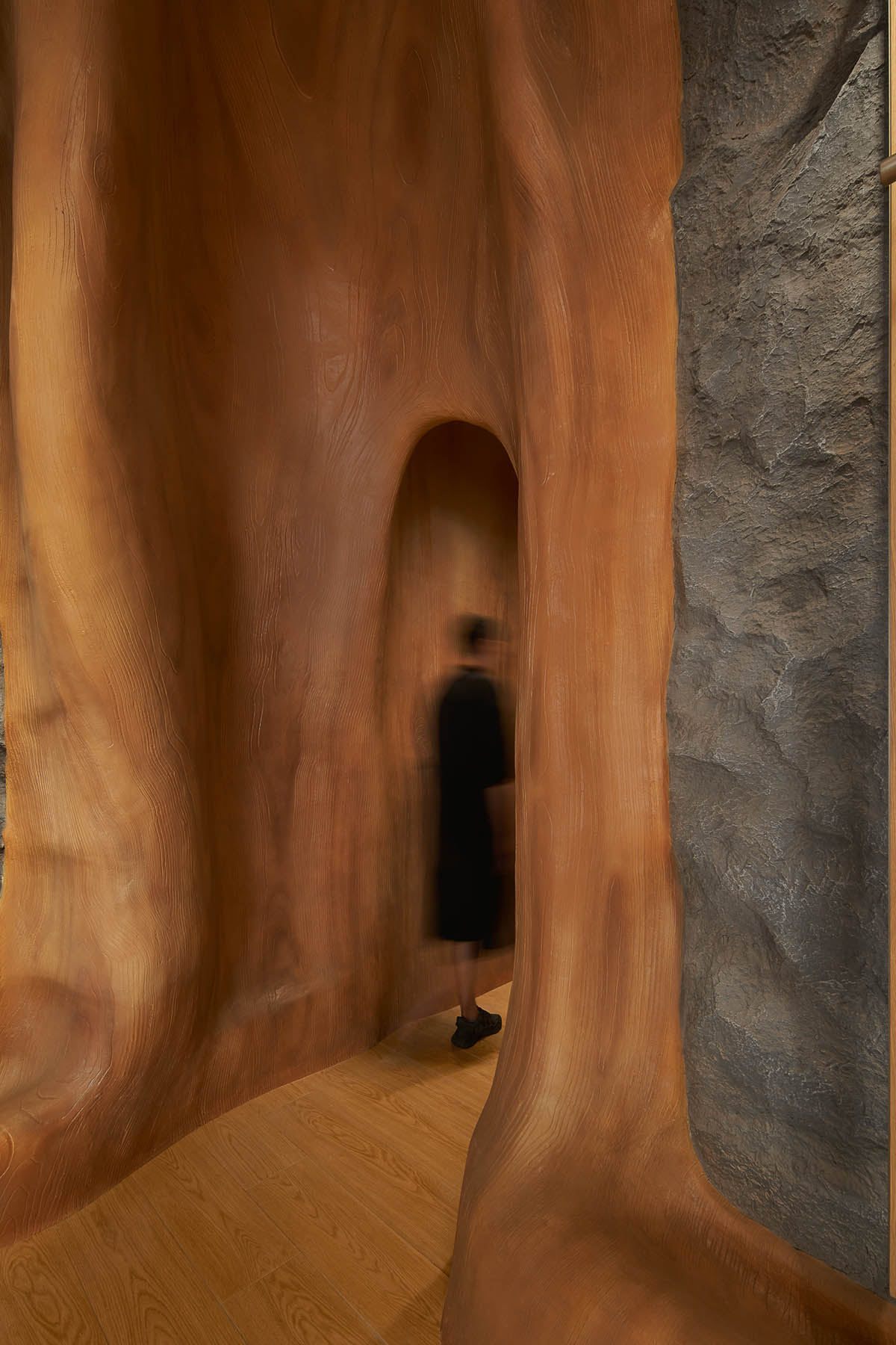 STILL YOUNG creates cave-like interiors for a store with wood and rock elements in Beijing 