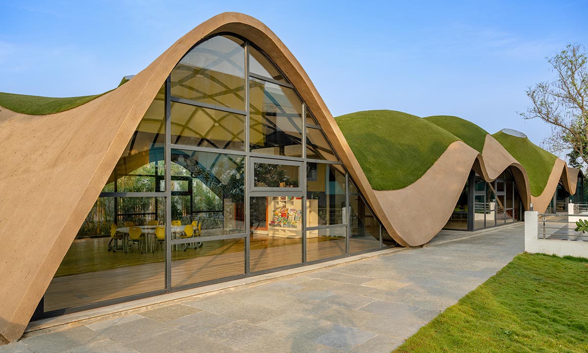 Undulating roof covers Cocoon School for unobstructed space in India 