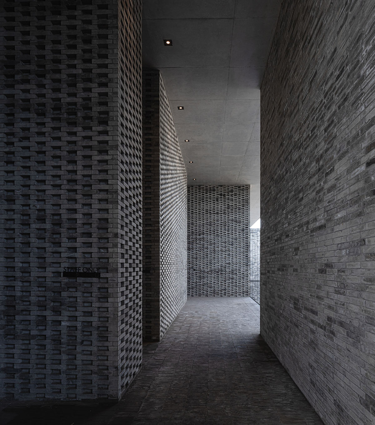 Grey brick walls wrap a factory building referencing to local construction methods in China 