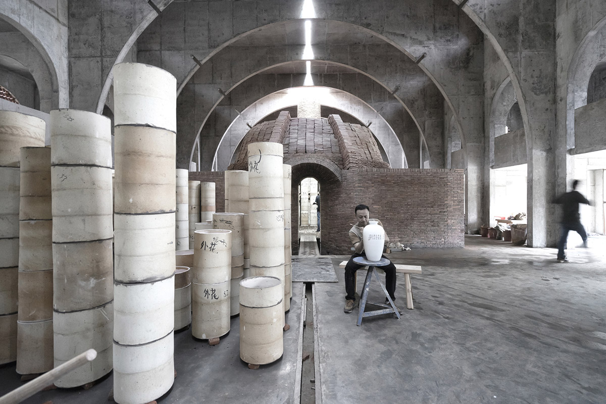 AZL Architects renovates old kiln building with concrete and brick arches in the middle of a forest
