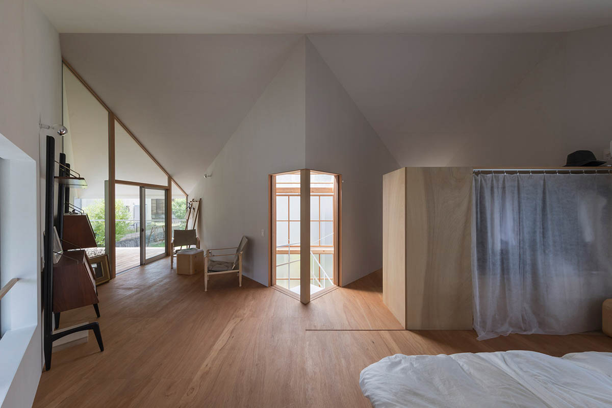 Huge corrugated polycarbonate wall lightens a cornered sunroom in house by Tato Architects