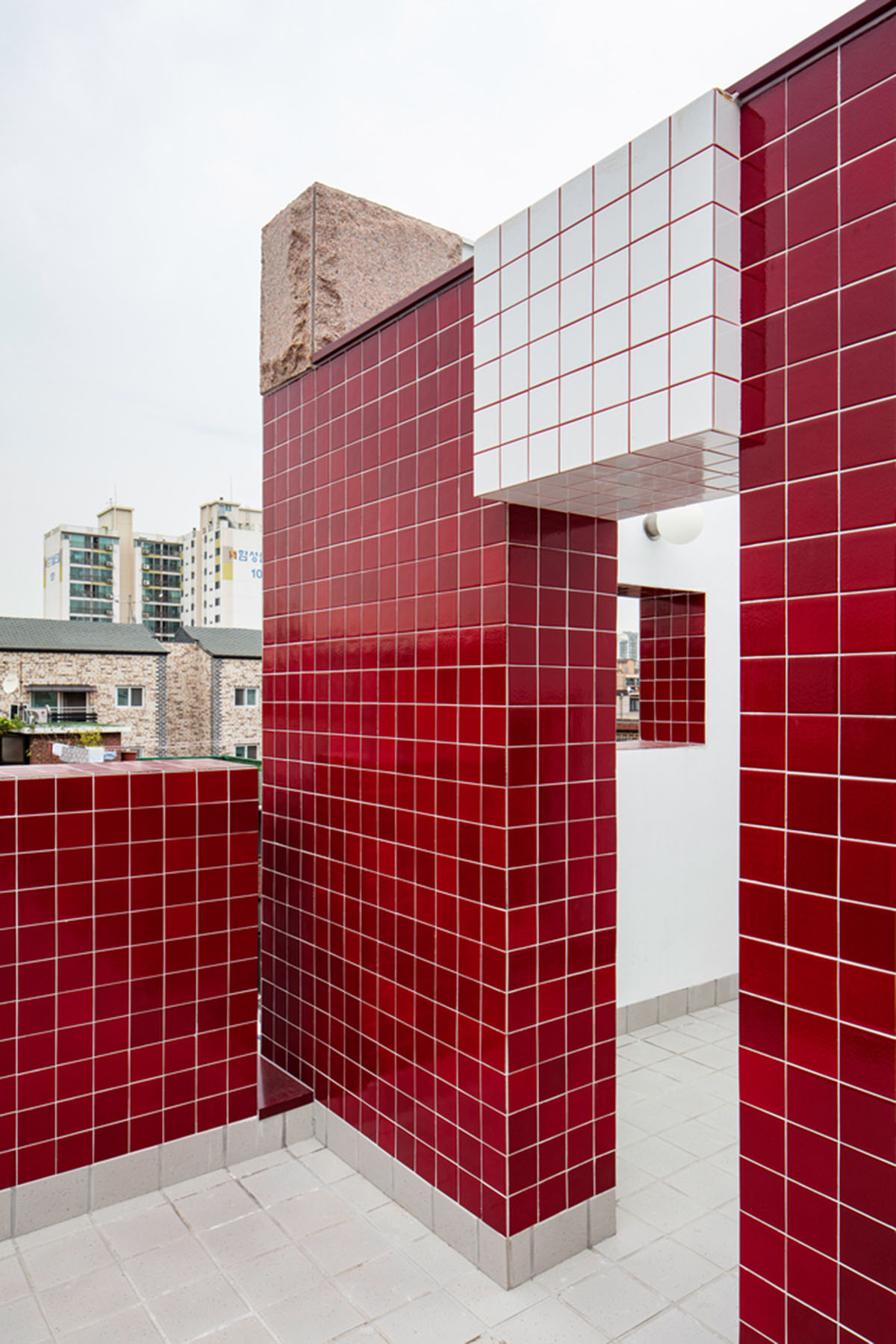 aoa architects uses red marble tiles to clad this apartment in South Korean neighborhood