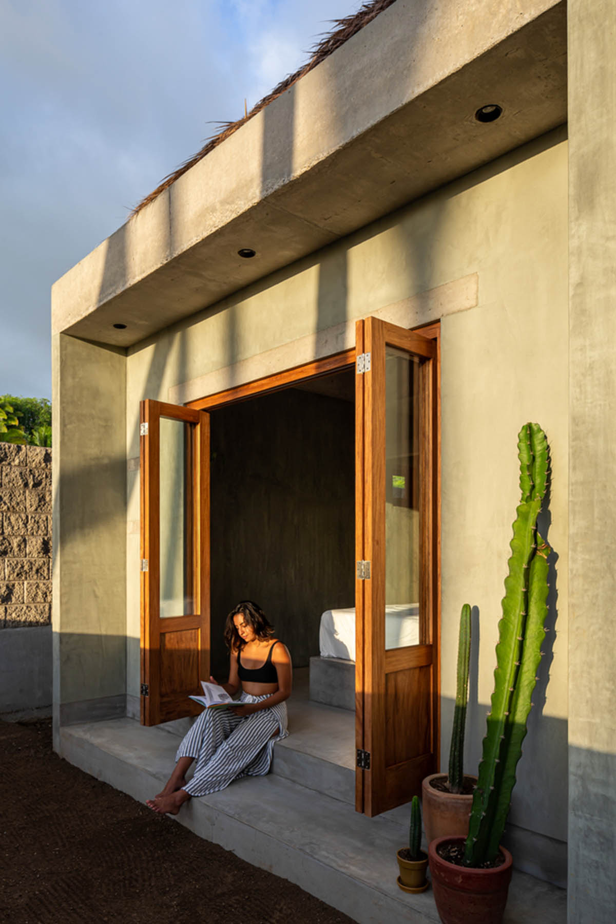 PALMA's small bungalow combines two functions with thatched roofs and a central patio in Mexico
