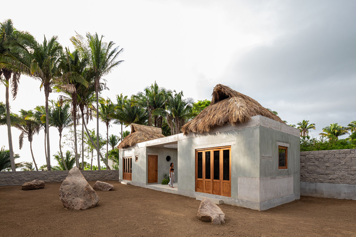 PALMA's small bungalow combines two functions with thatched roofs and a central patio in Mexico
