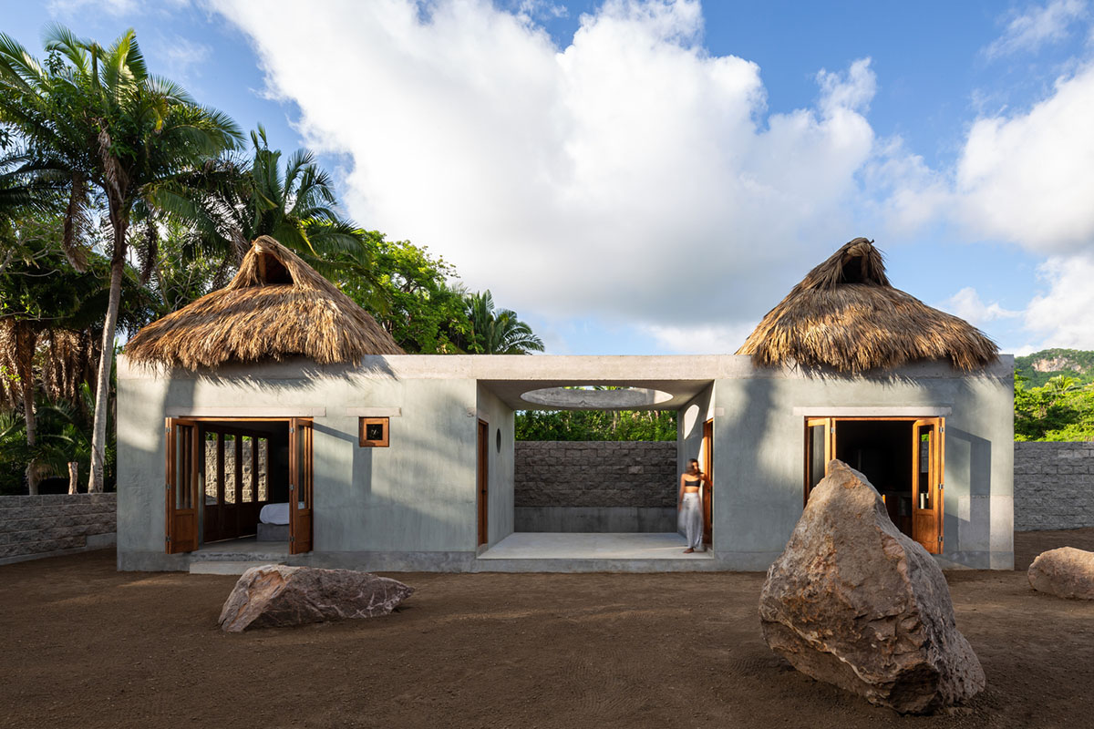 PALMA's small bungalow combines two functions with thatched roofs and a central patio in Mexico
