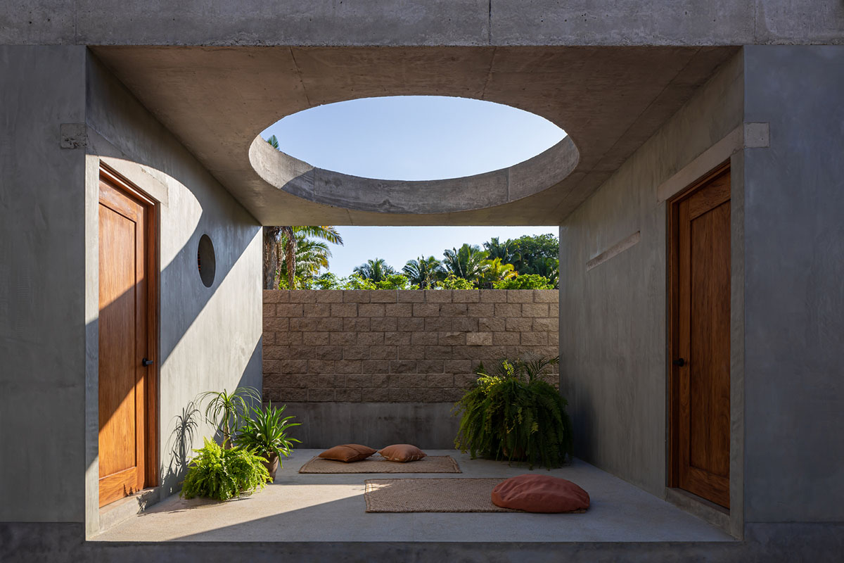 PALMA's small bungalow combines two functions with thatched roofs and a central patio in Mexico