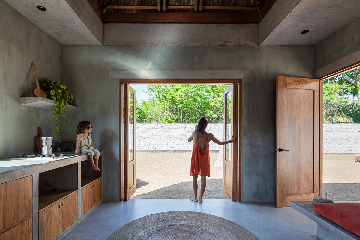 PALMA's small bungalow combines two functions with thatched roofs and a central patio in Mexico