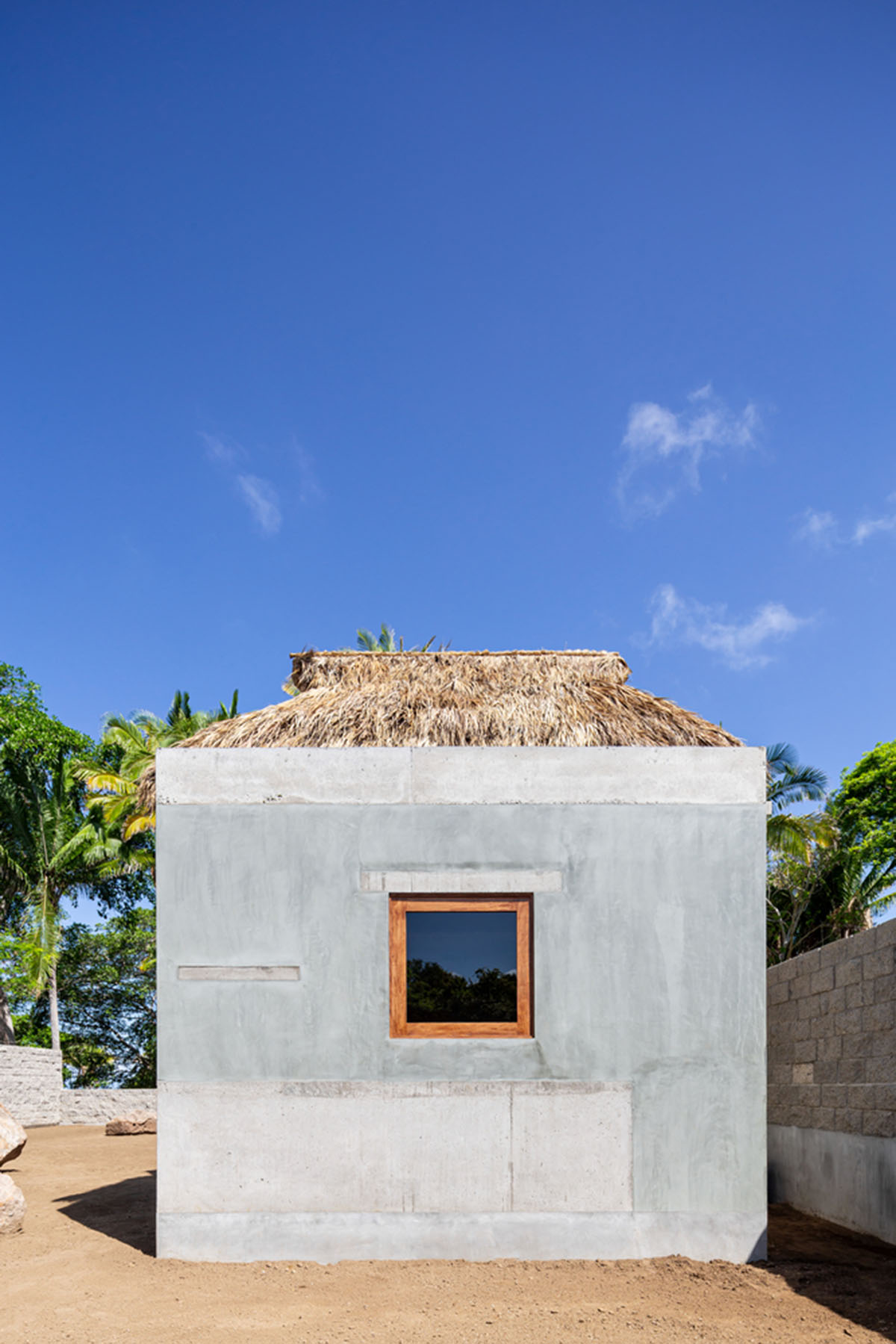 PALMA's small bungalow combines two functions with thatched roofs and a central patio in Mexico