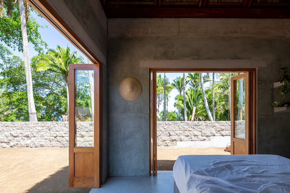 PALMA's small bungalow combines two functions with thatched roofs and a central patio in Mexico
