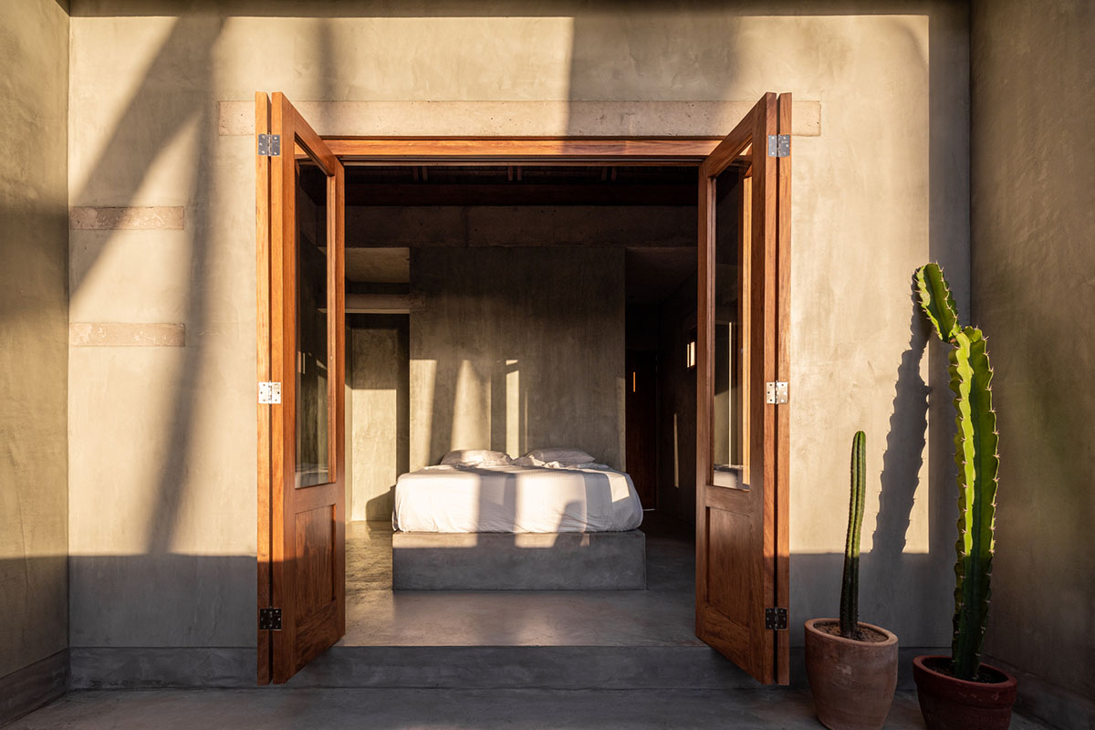 PALMA's small bungalow combines two functions with thatched roofs and a central patio in Mexico