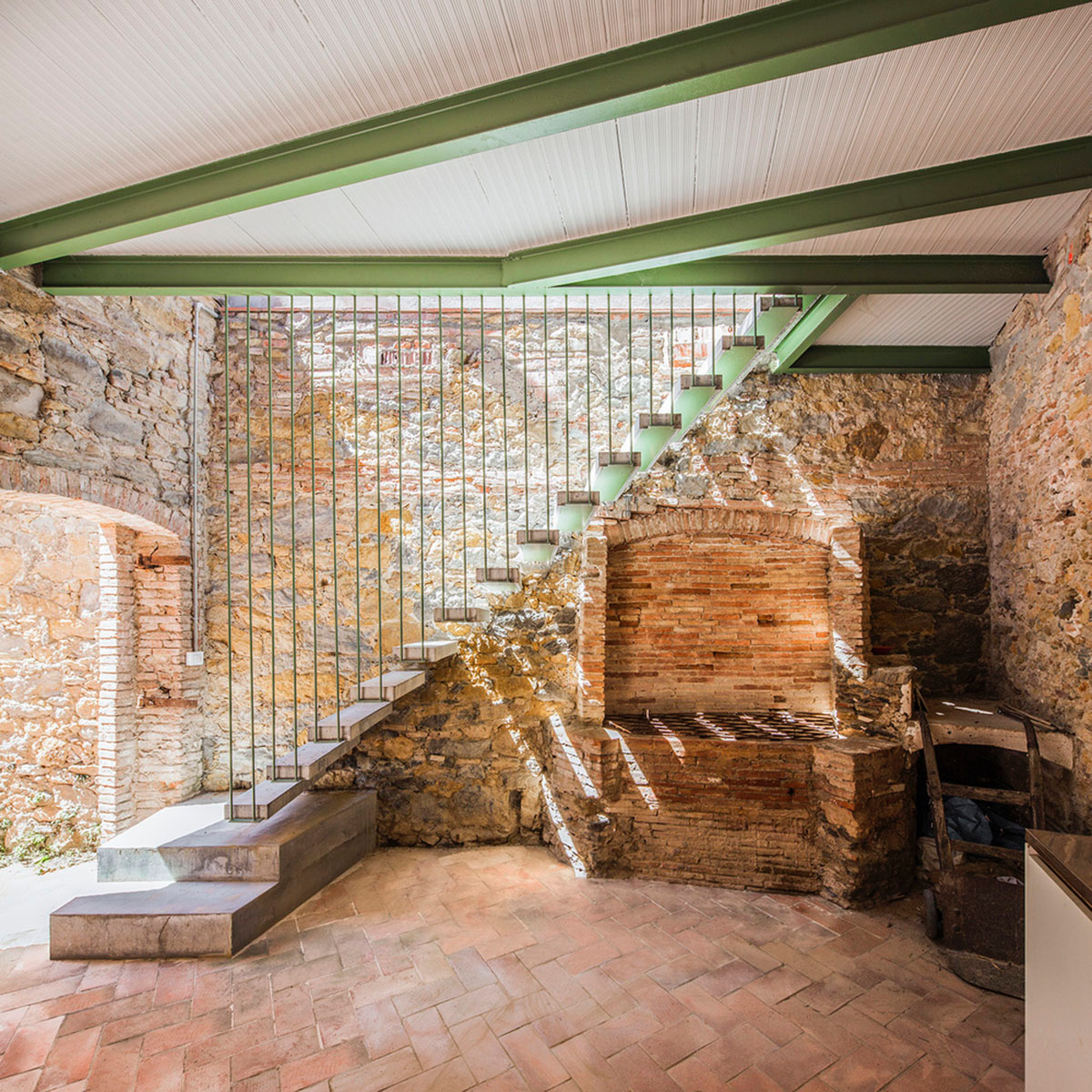 Anna & Eugeni Bach converts former chocolate factory into residence with stone walls in Spain