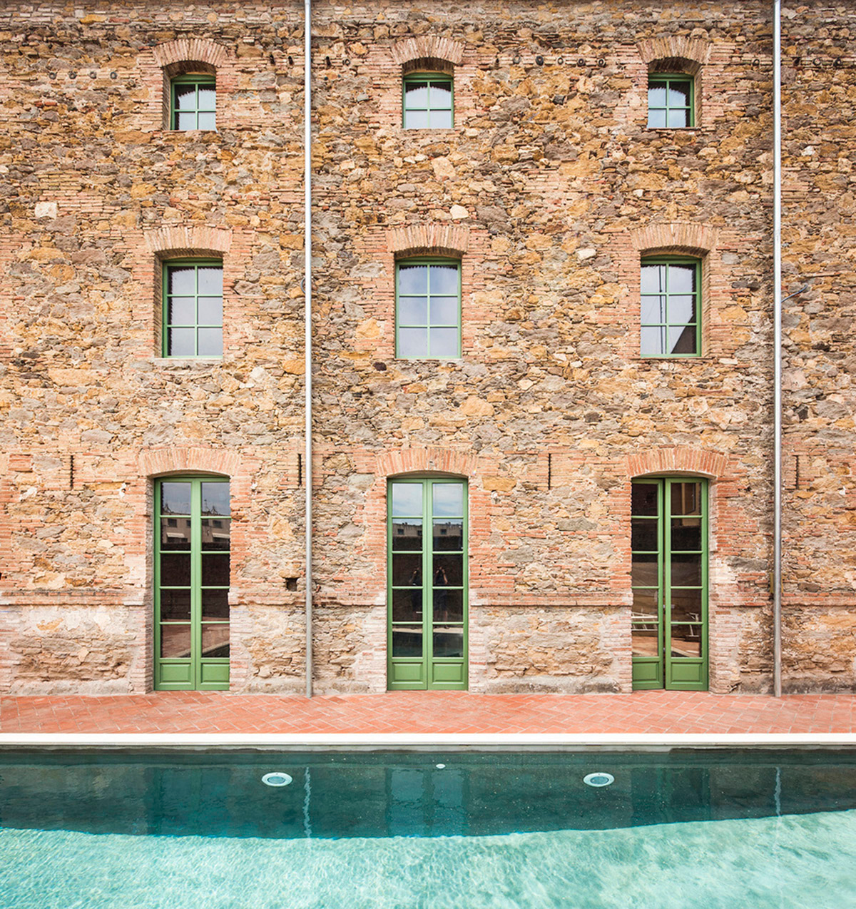 Anna & Eugeni Bach converts former chocolate factory into residence with stone walls in Spain