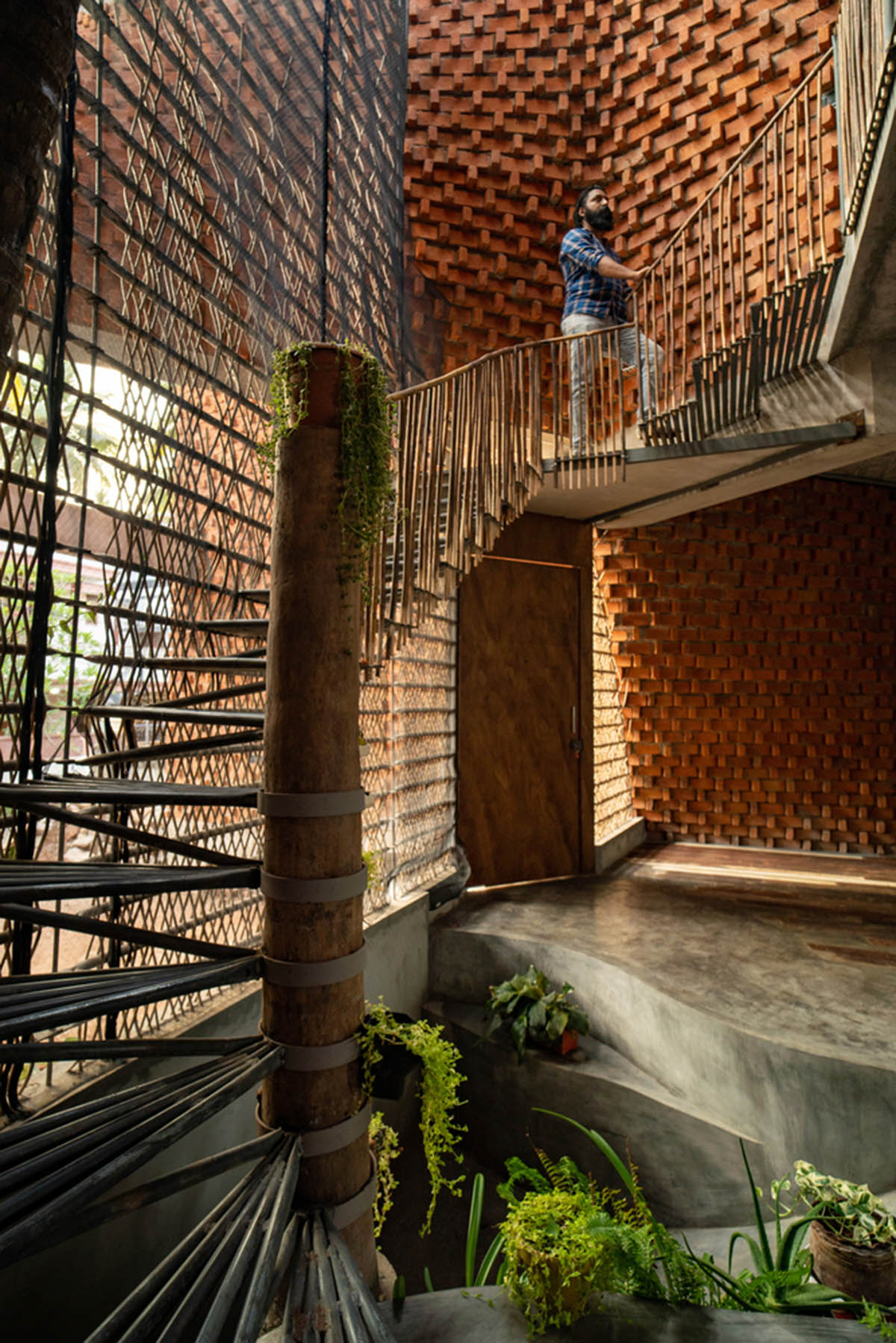 Wallmakers create slanting brick walls for Pirouette House in India to create larger interior spaces