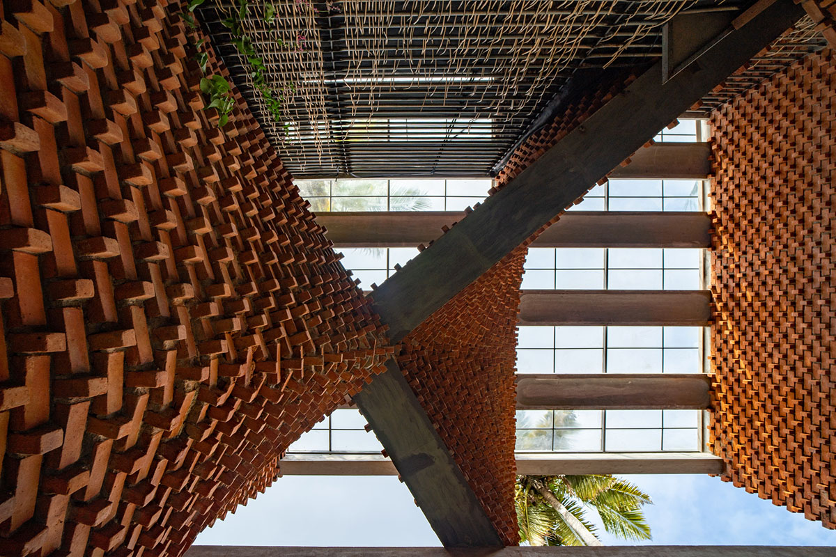 Wallmakers create slanting brick walls for Pirouette House in India to create larger interior spaces
