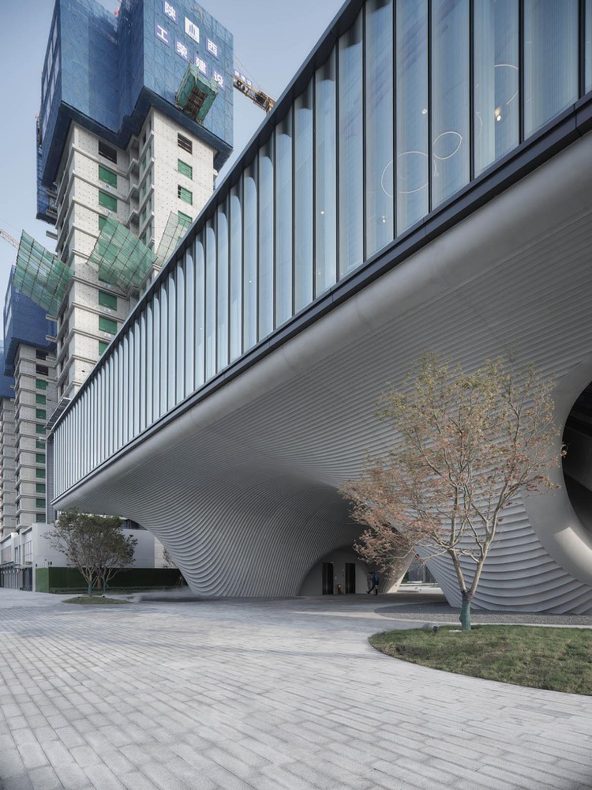 Community Center in Xi&rsquo;an is raised on sculptural base that features a rippling effect
