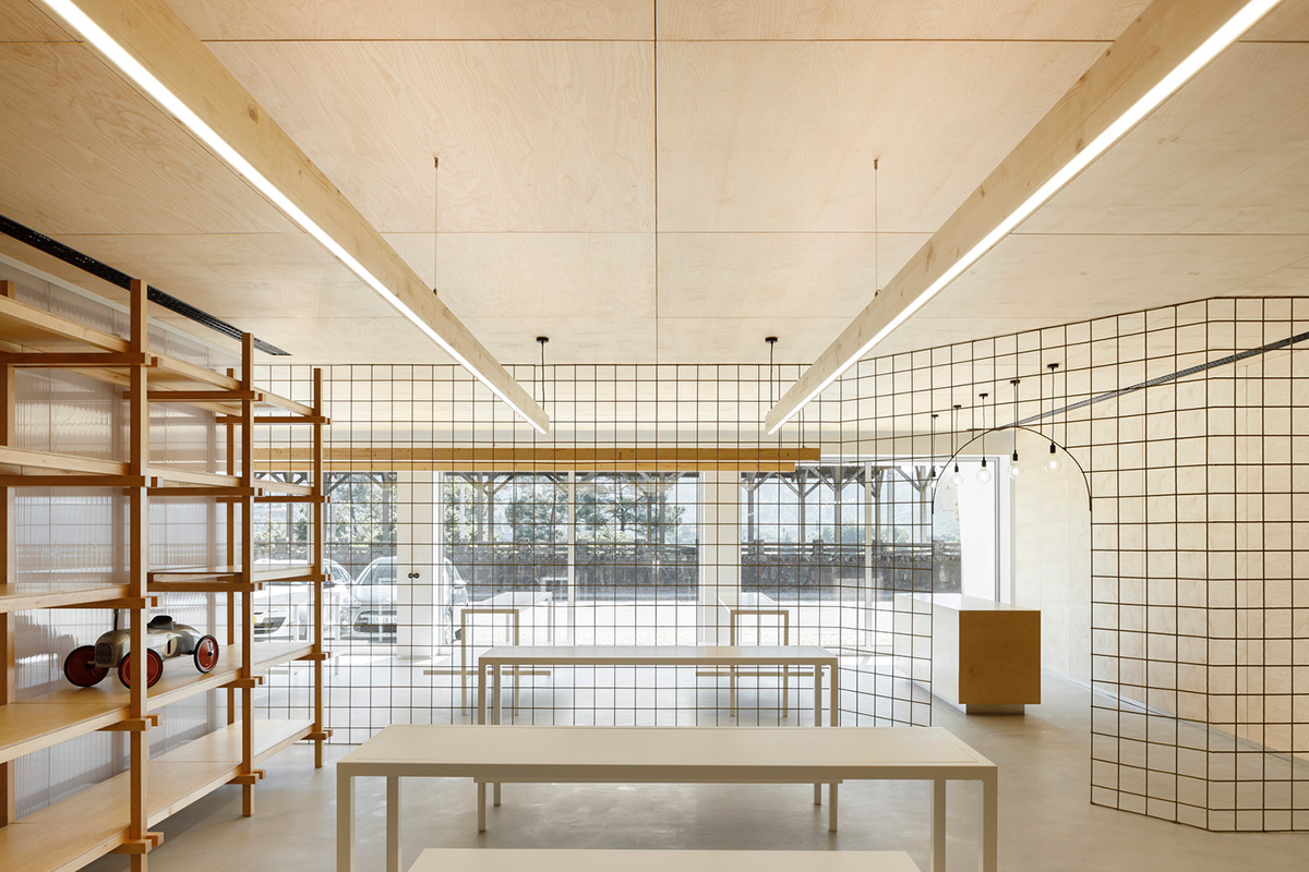 stu.dere divides interior space with golden wire meshes for multiple uses in this store in Portugal