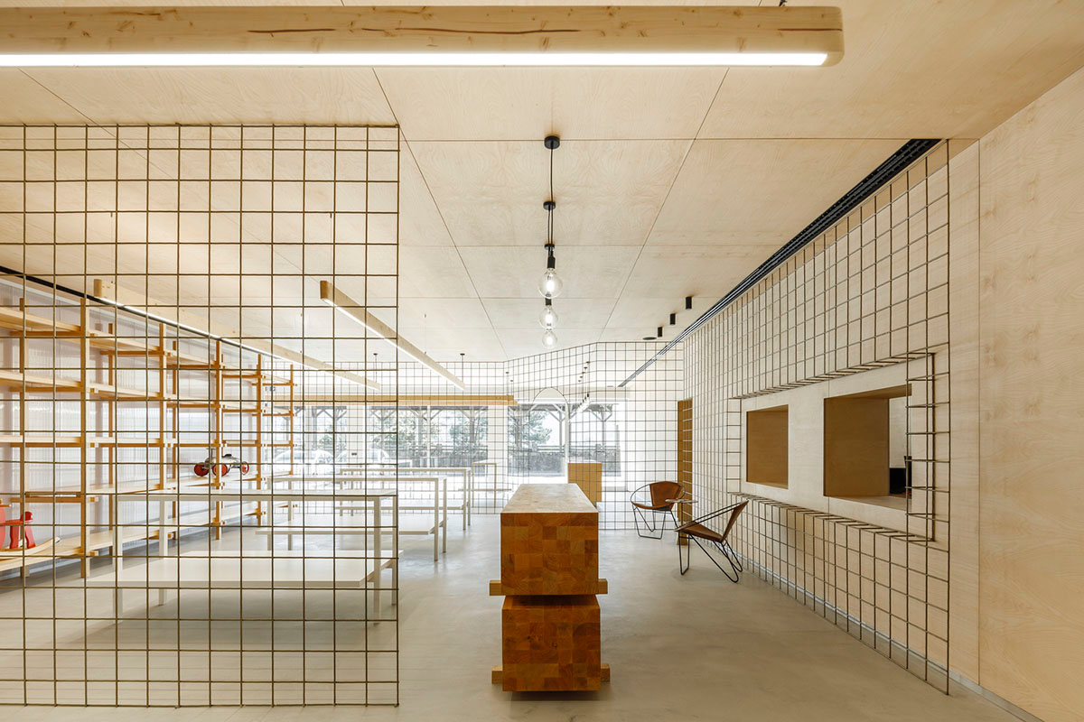 stu.dere divides interior space with golden wire meshes for multiple uses in this store in Portugal